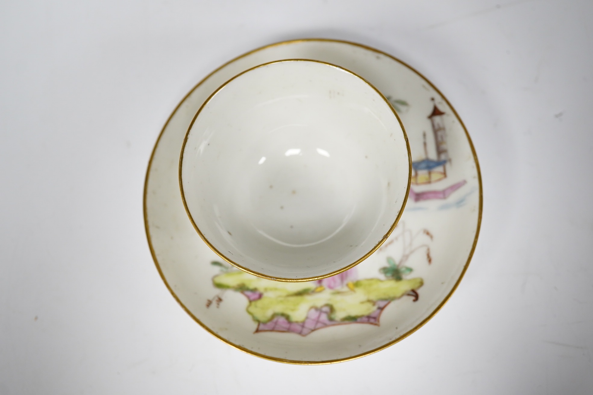 A Nove porcelain tea bowl and saucer, c.1770-75, hand painted with Chinese figures, iron red asterisk marks, 11.5cm in diameter